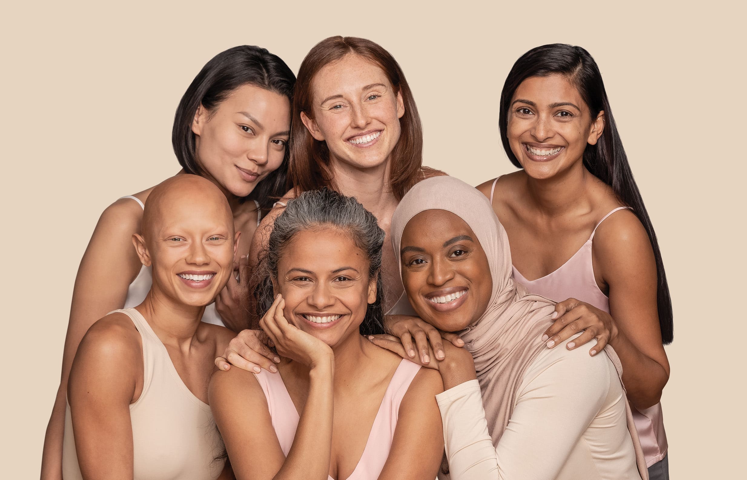 Three women from different ethnicities sitting and three other women standing behind them and smiling
