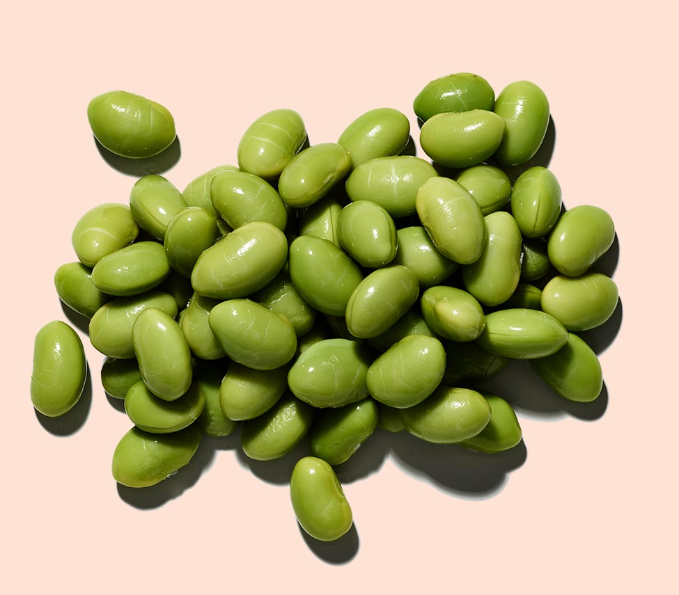 pile of soy beans against a peach background