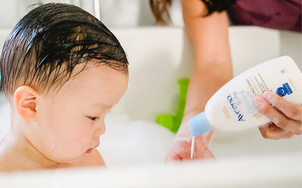 A baby taking a bubble bath with AVEENO® Baby Eczema Care product